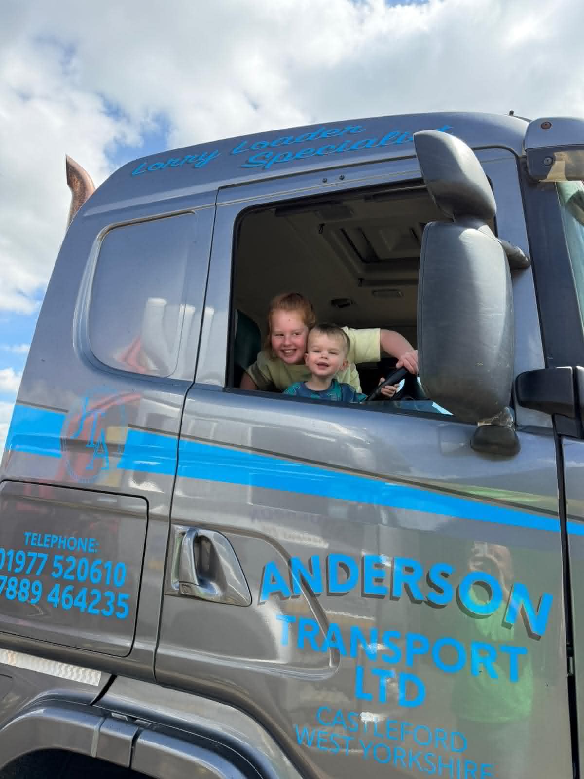 The next generation - family members smiling in the cab of an Anderson Transport lorry